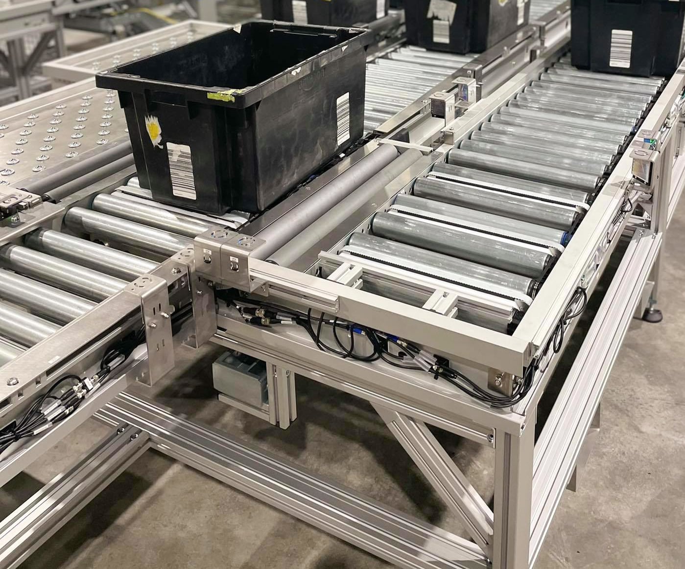 Our transfer units for roller conveyors help you transfer products from one line to another, as can be seen on the photo where a crate is being transferred.